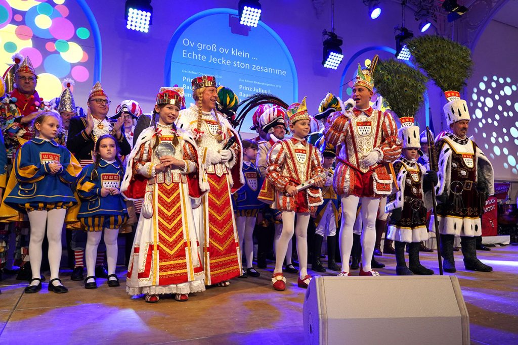 Groß und Klein auf der Bühne: Björn Griesemann konnte beide Kölner Dreigestirne zur Sitzung in der Flora begrüßen und ernannte Prinz Sascha I., Bauer Werner und Jungfrau Frieda zum Leutnant der Reserve der Blauen Funken